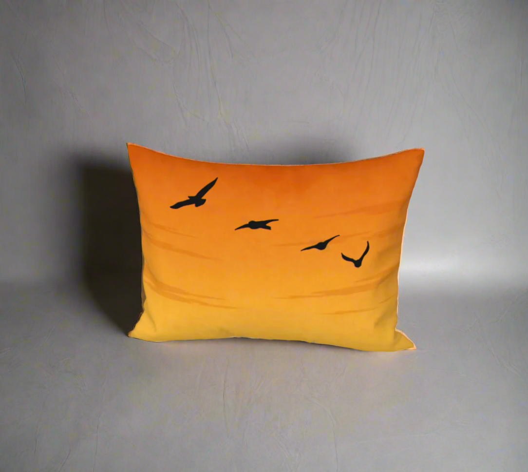 Orange pillow with black bird illustrations on a white background
